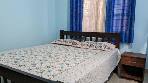 a bedroom with a bed with blue walls at Delight Homestays Coorg in Kushālnagar