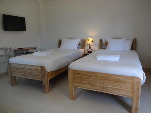 two beds sitting next to each other in a room at Rena House Chiang Mai in Chiang Mai