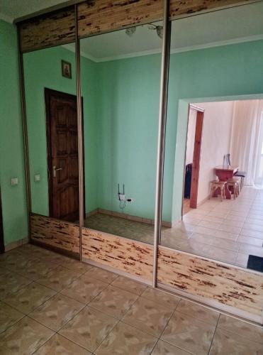a large mirror in a room with green walls at Apartment on Kravchuka, 11b in Lutsk