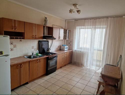 a kitchen with wooden cabinets and a sink and a window at Apartment on Kravchuka, 11b in Lutsk