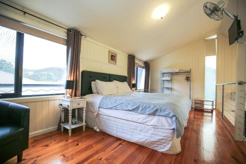 a bedroom with a bed and a large window at Allambie Cottages - Villa 1 in Bright