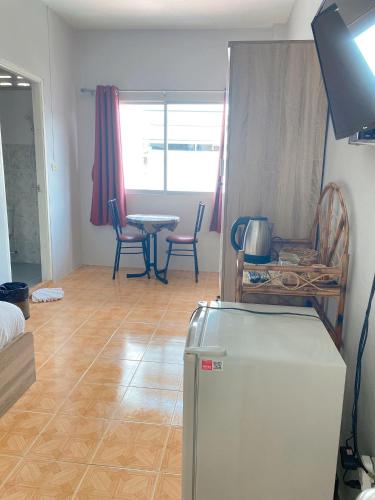 a living room with a refrigerator and a table at 2 Vikings Guesthouse in Karon Beach