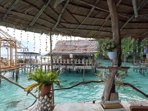 un resort con un mucchio di tavoli e acqua di Yenbainus homestay a Yennanas Besir