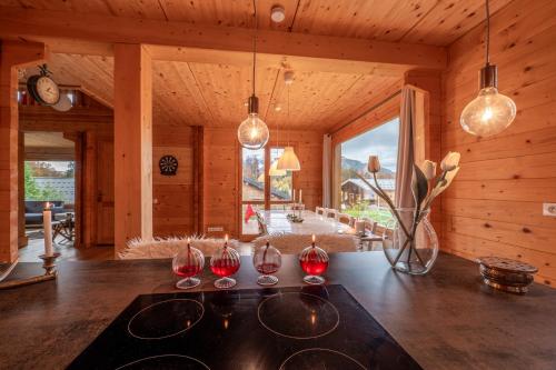a room with three wine glasses on a table at Chalet aux Cerfs - Maison pour 10 vue montagne in Arâches-la-Frasse