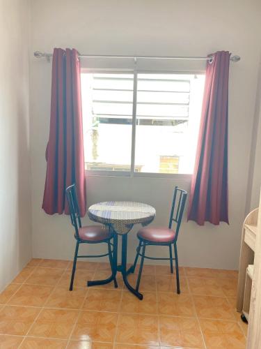 a table and two chairs in a room with a window at 2 Vikings Guesthouse in Karon Beach