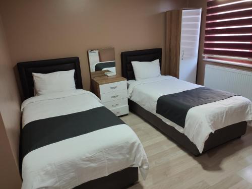 a bedroom with two beds and a mirror at ONKA OTEL in Zonguldak