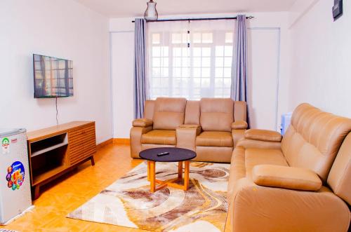 a living room with two couches and a tv at Buvan homes in Eldoret