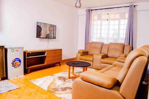 a living room with a couch and a tv at Buvan homes in Eldoret