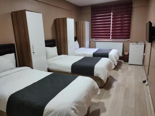 a hotel room with three beds and a window at ONKA OTEL in Zonguldak
