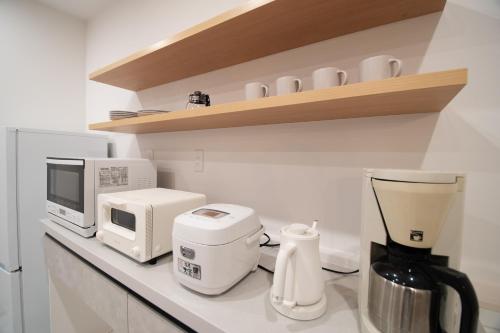 a kitchen counter with a coffee maker and a microwave at ユニテ蔵王ジョーニダ リゾート in Yamagata