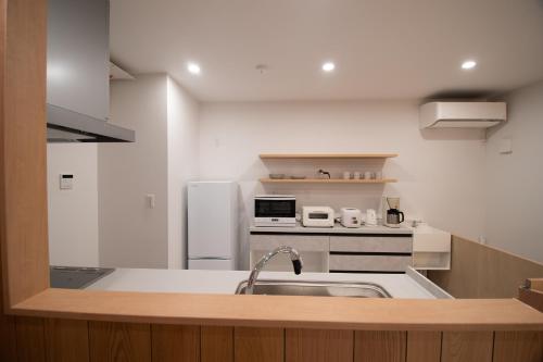 a kitchen with a sink and a refrigerator at ユニテ蔵王ジョーニダ リゾート in Yamagata