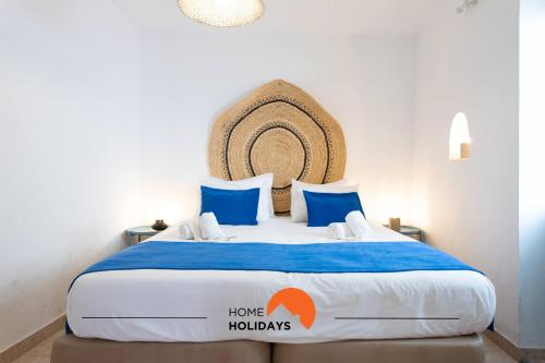 a bedroom with a large bed with blue and white sheets at #197 Casa Gili by Home Holidays in Albufeira