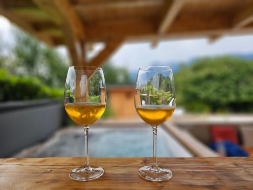 dos copas de vino sentadas en una mesa de madera en Un moment de détente, en Gilly-sur-Isère