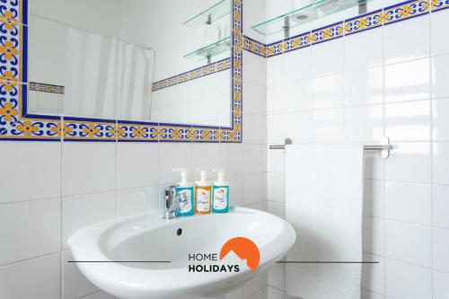a white bathroom with a sink and a mirror at #197 Casa Gili by Home Holidays in Albufeira