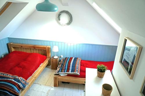 a bedroom with a red bed and a table at Ostoja Bukowo, Domek 9,1 'Stilia' in Borowy Młyn