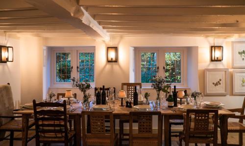 a dining room with a table and chairs and windows at The Three Horseshoes in Burford