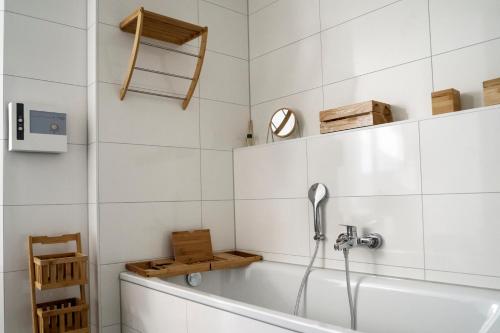 a bath tub in a bathroom with white tiles at Park-Apartment Scharmützelsee Wohnung 5 in Wendisch Rietz