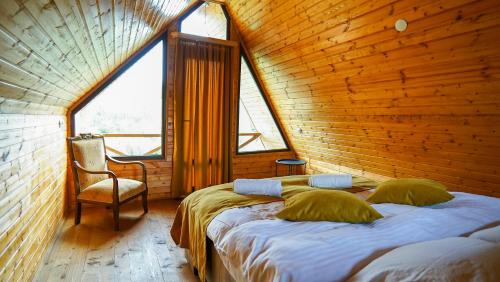 ein Schlafzimmer mit einem Bett in einem Holzzimmer in der Unterkunft Chateau Kiramala in Lagodechi