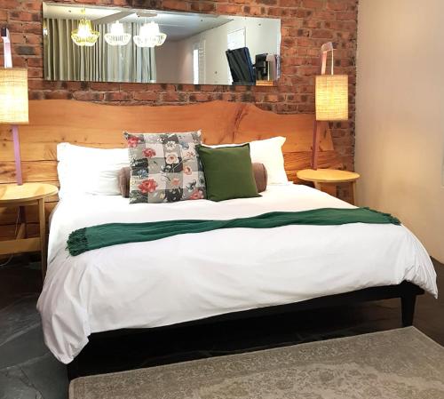 a bedroom with a large white bed with pillows at Concierge Hotel in Durban
