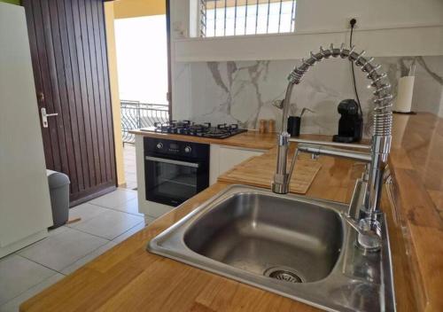 a kitchen with a sink and a stove at Maïlly - Charmante villa T5 in Capesterre-Belle-Eau