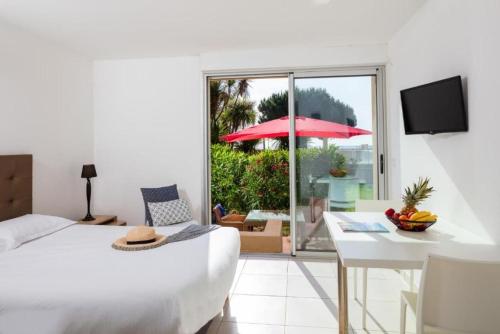 Habitación de hotel con cama, mesa y vistas a un patio. en Résidence Marina Bianca en Santa-Lucia-di-Moriani
