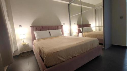 ein Schlafzimmer mit einem großen Bett und einem großen Spiegel in der Unterkunft Ermou Junior Suite by Aesthetic & Luxurious Living in Athen