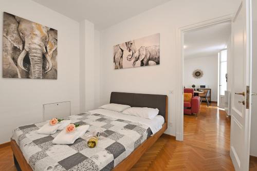 sypialnia z łóżkiem i dwoma obrazami na ścianie w obiekcie Amazing Lugano - Happy Rentals w mieście Lugano