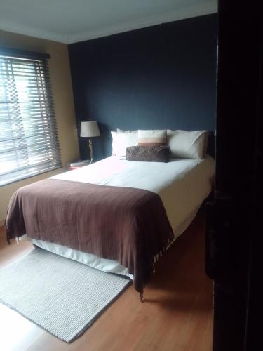 a bedroom with a large bed with a black wall at Room2rent Centurion in Pretoria