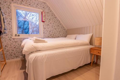 um quarto com uma cama e uma janela em Urban and stylish apartment in city centre em Tromsø
