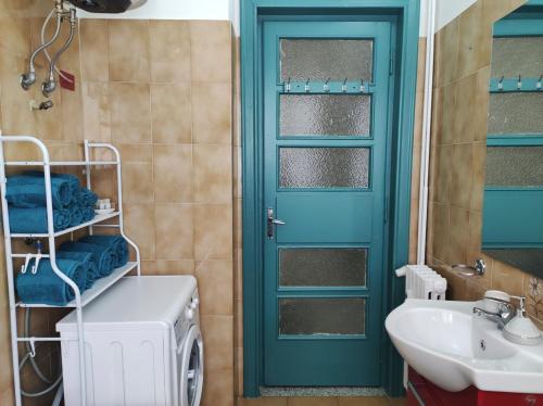 uma casa de banho com uma porta verde e um lavatório em Ca' Allegra - Centro em Asti