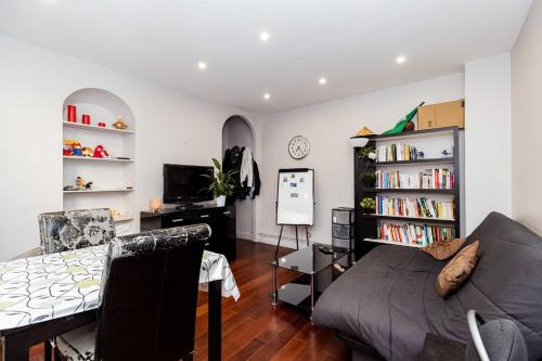 un salon avec un canapé et une table dans l'établissement JOLI et LUMINEUX T1 33 m dans un quartier calme, à Paris