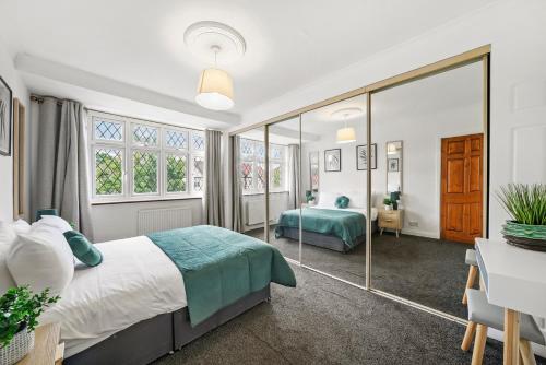 Un dormitorio con una cama, un escritorio y ventanas. en Greenford Hububb Stay, en Northolt