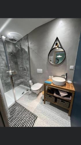 La salle de bains est pourvue d'une douche, d'un lavabo et d'un miroir. dans l'établissement L’éscale étape, 