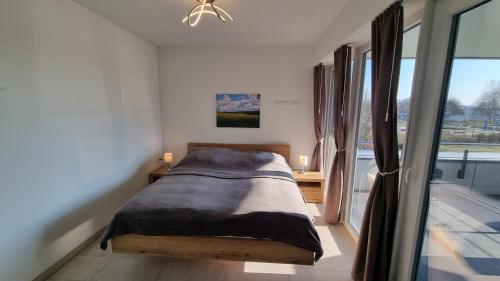 a bedroom with a bed and a large window at Park-Apartment Scharmützelsee Wohnung 9 in Wendisch Rietz