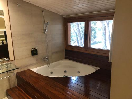 a bath tub in a bathroom with a window at Hotel Restaurante El Montico in Tordesillas