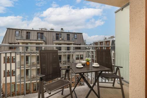 balkon ze stołem i krzesłami w obiekcie Apartamenty Aquamarina by Noclegi Renters w Świnoujściu