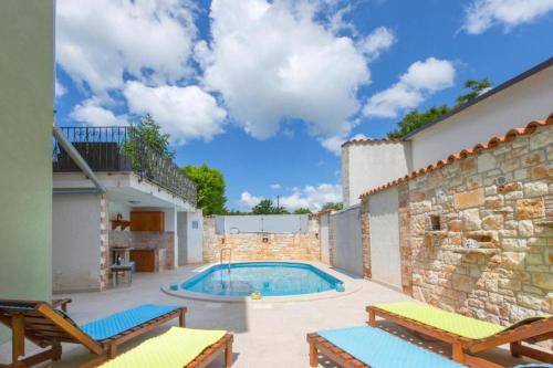 una piscina con 2 sillas y un edificio en Casa Menta near Pula - private villa for families & friends with Pool, Sauna, Fitness and Pool Heating, en Marčana