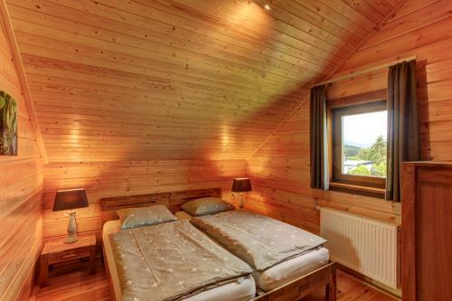 Bett in einem Holzzimmer mit Fenster in der Unterkunft Ecolodge 2 in Medebach