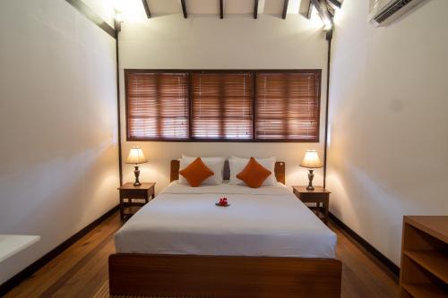 a bedroom with a bed with two lamps and a window at Nongsa Village in Nongsa