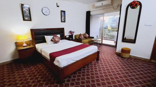 a bedroom with a bed and a couch in a room at Garden Residents Uttara - Lake View in Dhaka