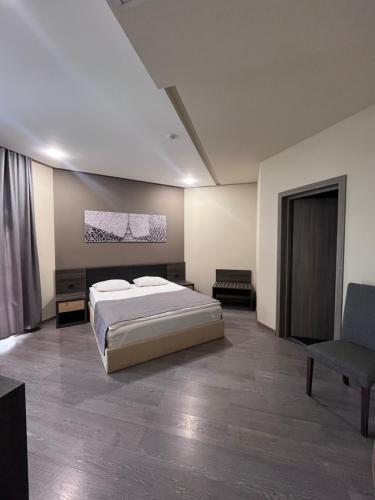 a large bedroom with a bed and a chair at Bien hotel in Yerevan