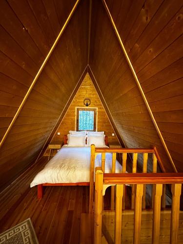 a bedroom with a bed in a wooden attic at Doka Valea Sebesului A-Frame in Sebeşu
