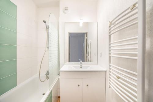 a white bathroom with a sink and a shower at Villa proche Deauville in Auberville