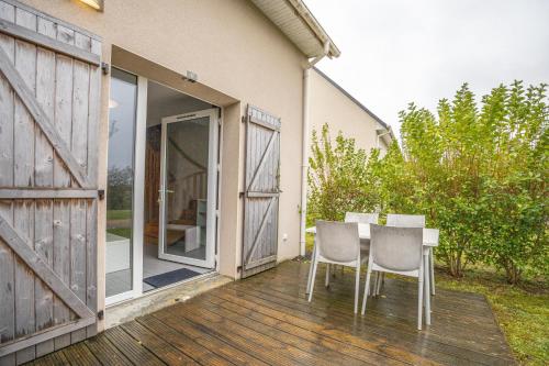 奧貝爾維爾的住宿－Villa proche Deauville，露台设有桌椅