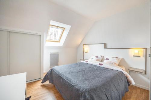 奧貝爾維爾的住宿－Villa proche Deauville，一间卧室配有一张带蓝色毯子的床