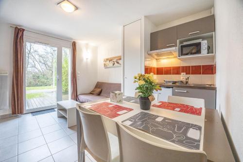 a kitchen with a table and chairs in a room at Villa proche Deauville in Auberville