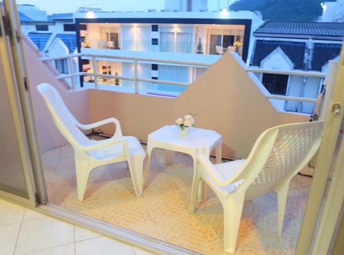 a balcony with two chairs and a table at B-Home Residence in Patong Beach