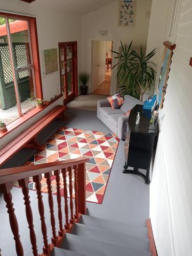 a living room with a staircase and a couch at Rata Lodge Accommodation in Otira