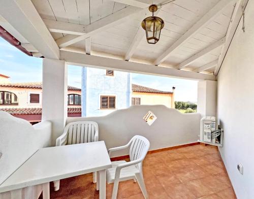 a patio with white chairs and tables and a ceiling at ISA-Residence in Orosei just 3 km from the beach, apartments with air conditioning and private outdoor area in Orosei