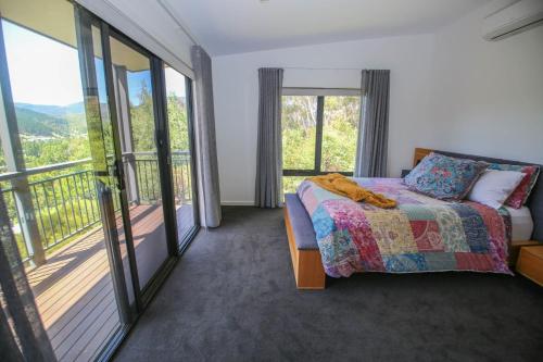 a bedroom with a bed and a balcony at Apex Villa in Bright